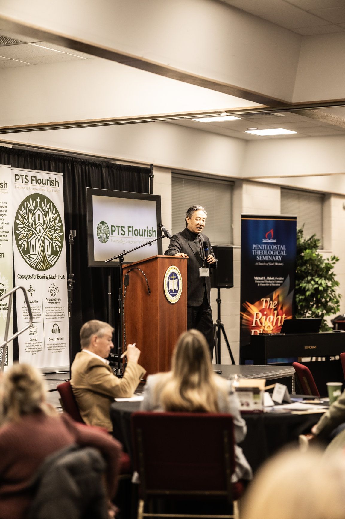A man is standing at a podium giving a presentation to a group of people.