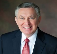 A man in a suit is sitting at a table with a can of sprite on it.