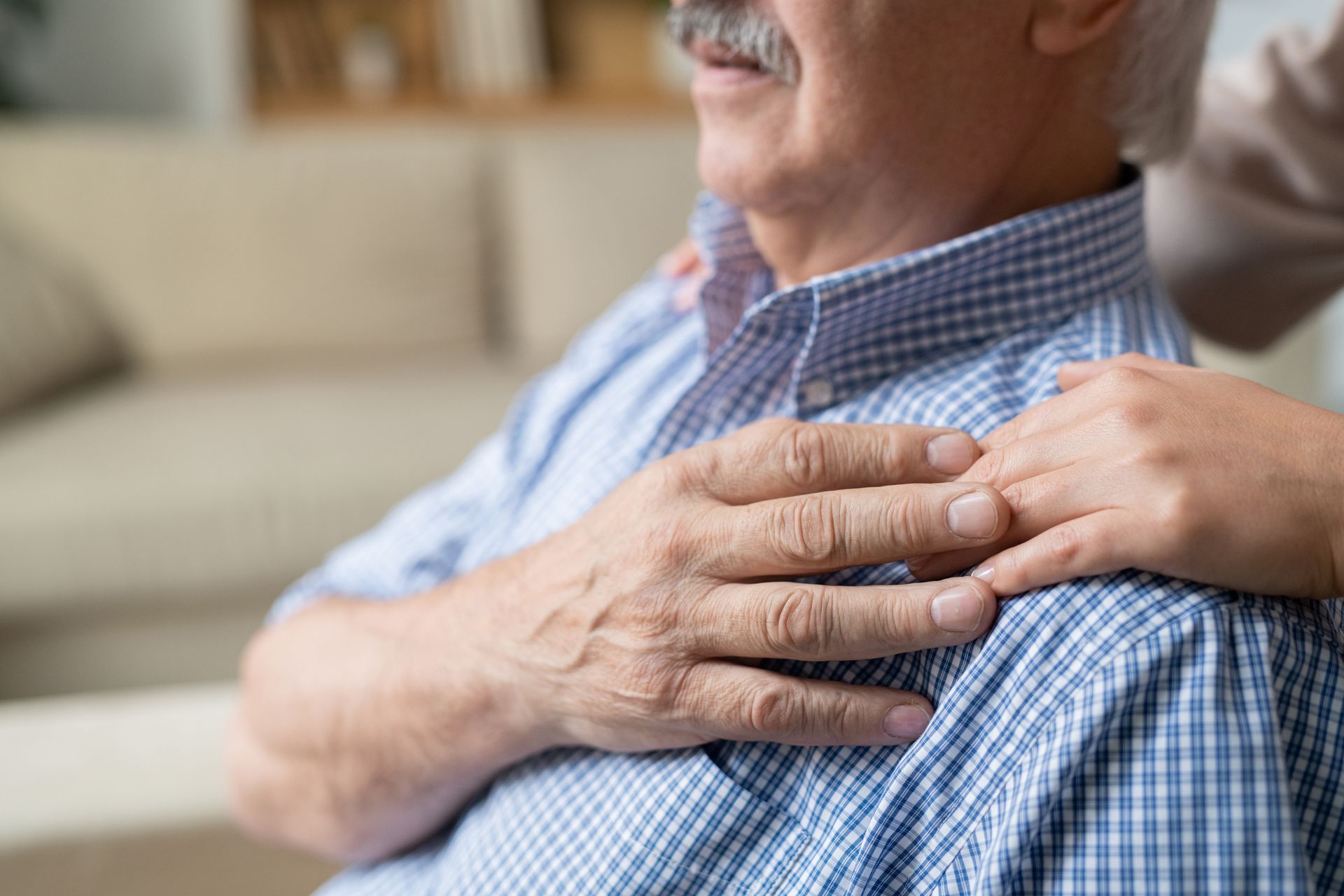 elderly person holding the hand of a person out of frame