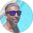 Hombre con gafas de sol reflectantes frente a un fondo de piscina azul brillante