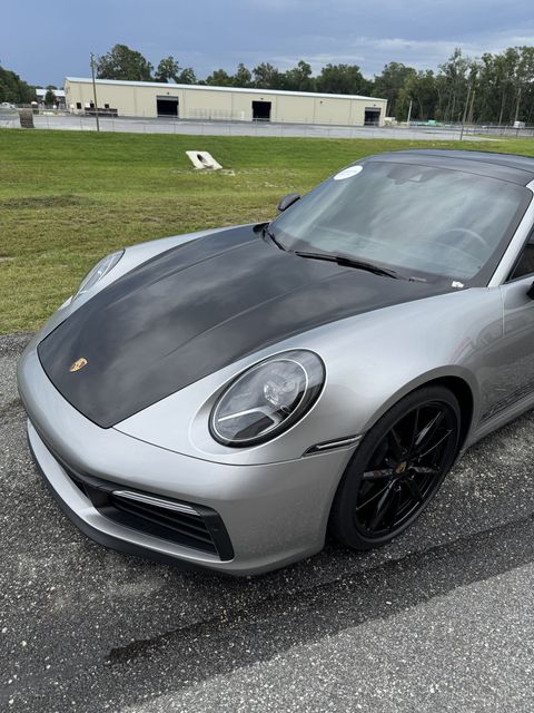 Gloved hands cleaning a white car’s exterior in a car wash detail shop - Window Tint and Paint Film Protection in Ocala, FL