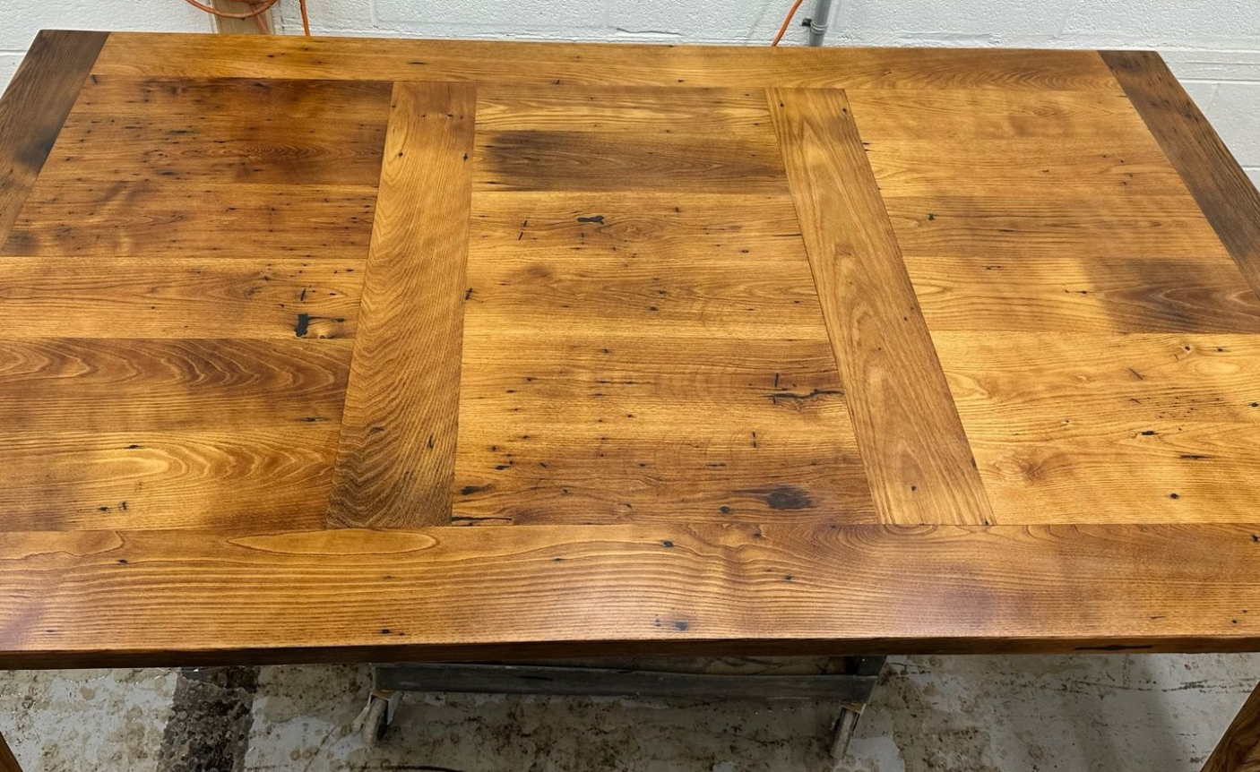 Wooden table top with a patchwork-style grain pattern in warm brown tones