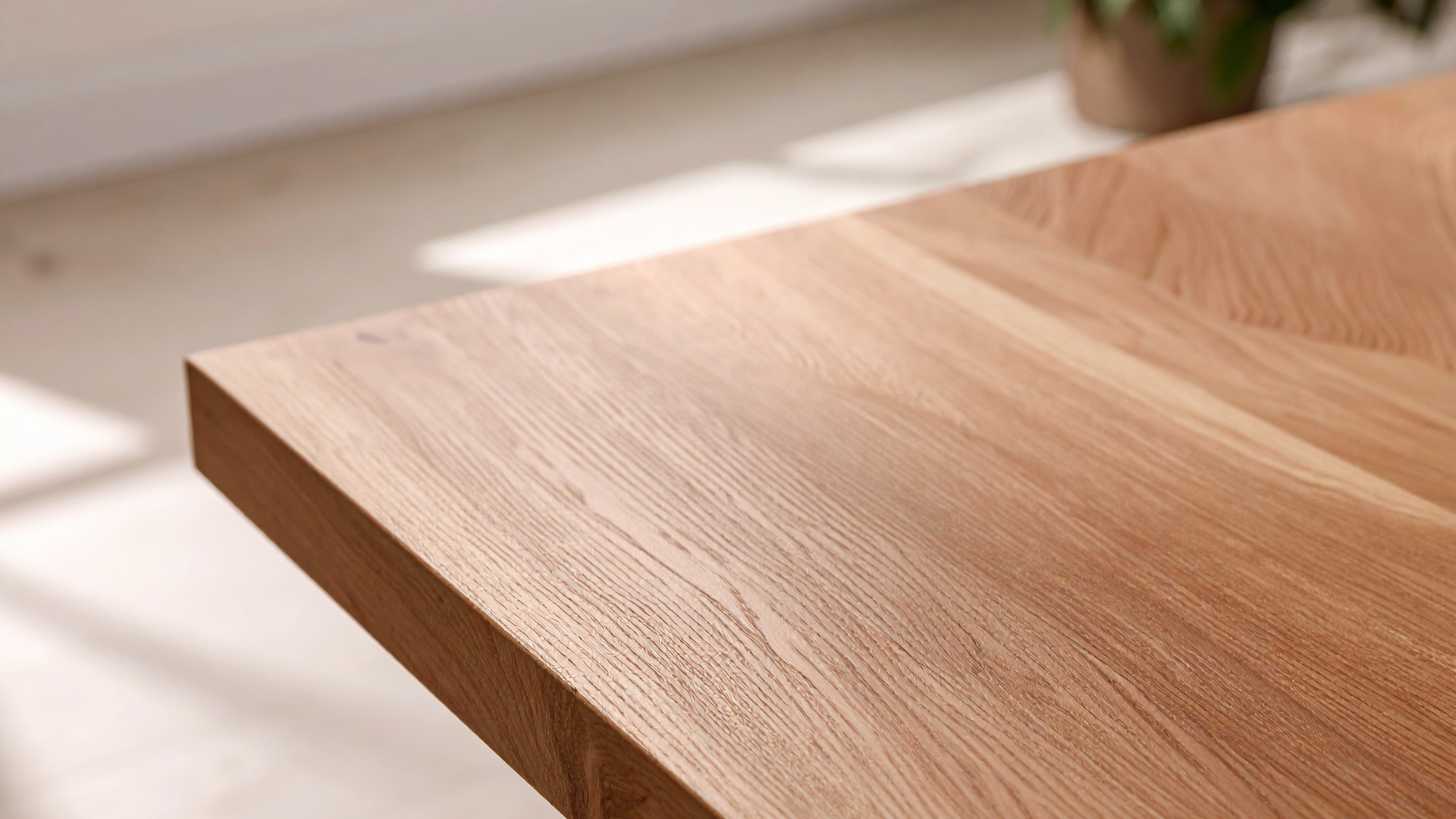 Close-up of a light wood tabletop with soft sunlight and blurred greenery in the background