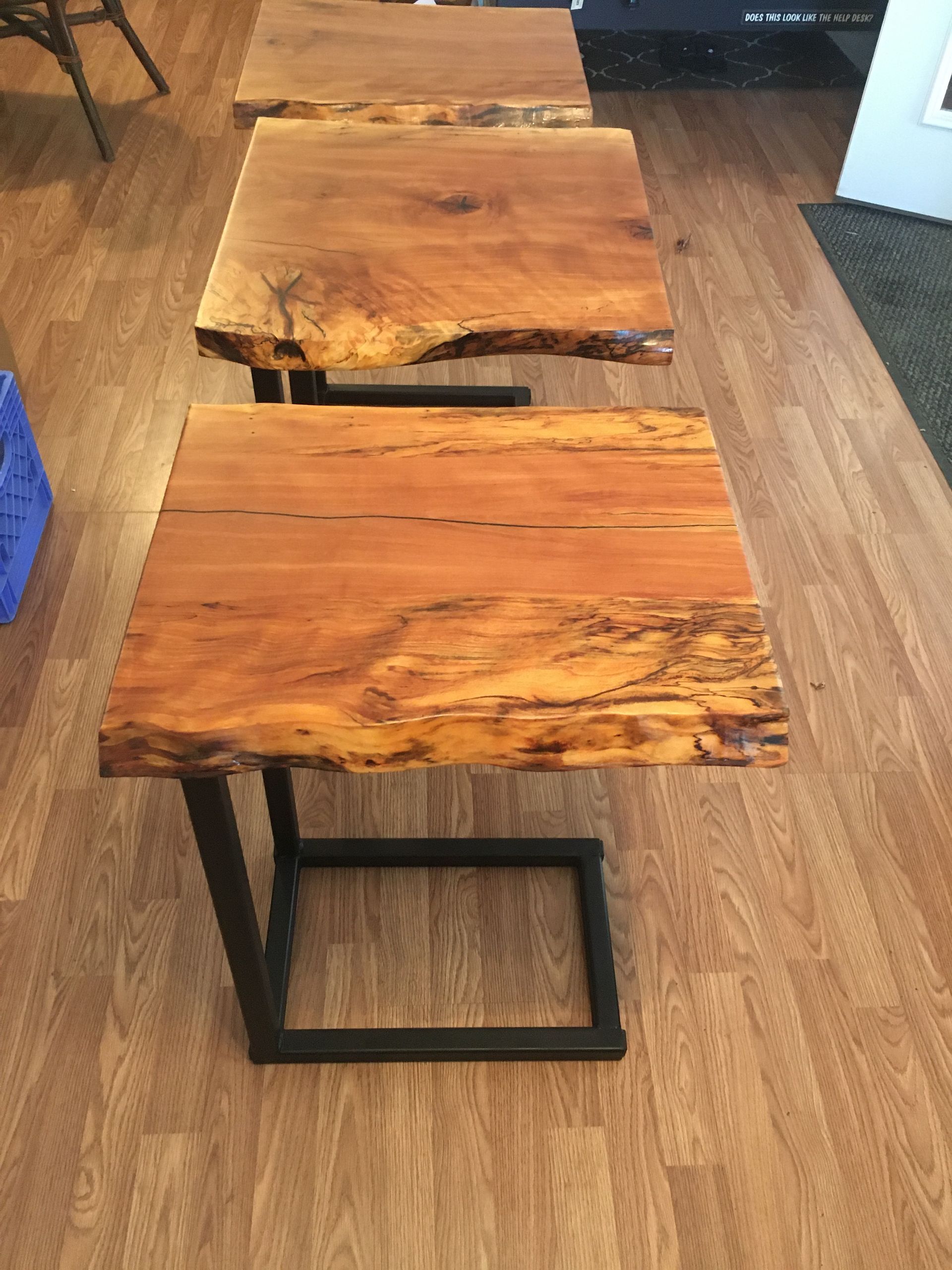 Two rustic wooden side tables with black metal legs on a hardwood floor