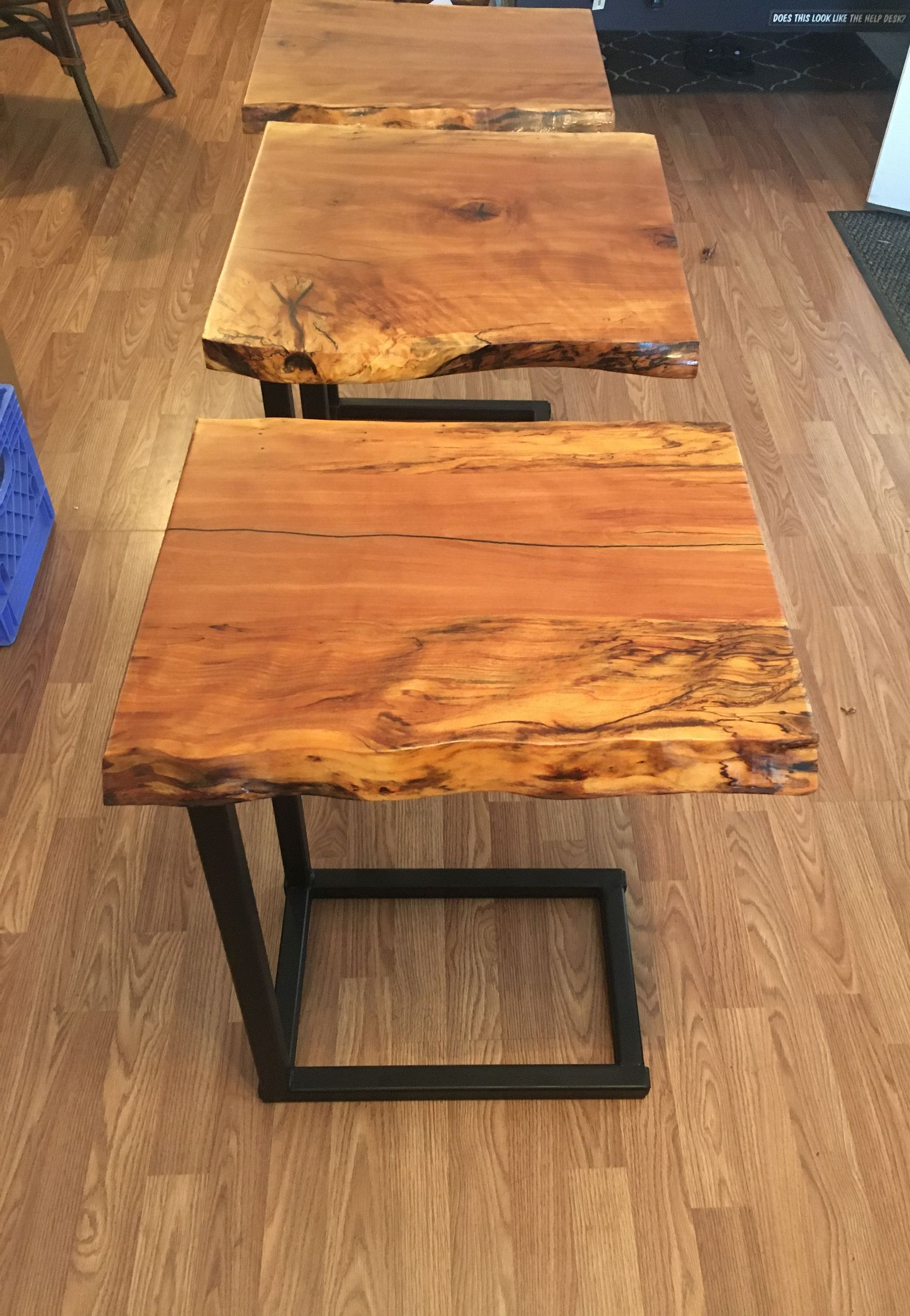 Two rustic wooden side tables with black metal legs on a hardwood floor