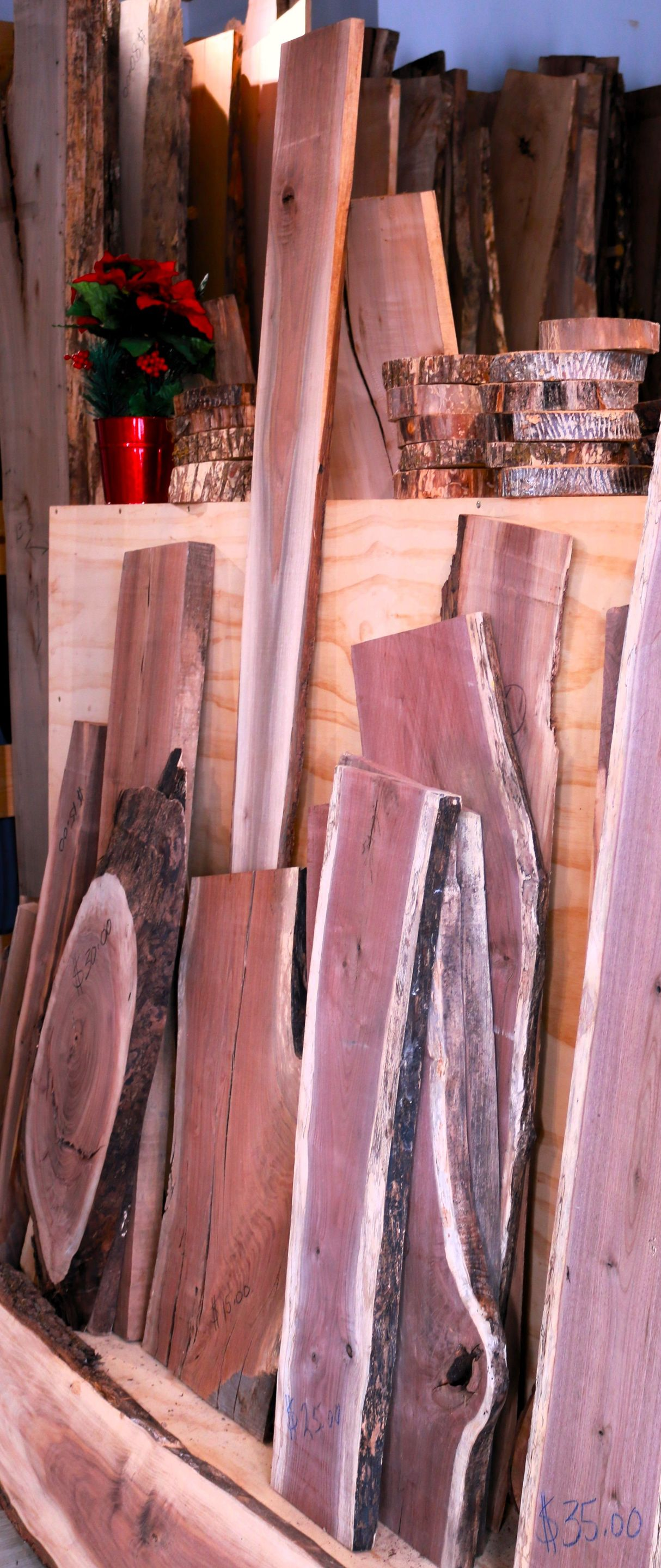 Stack of weathered wooden planks in pink, brown, and gray tones, leaning vertically in a rustic setting