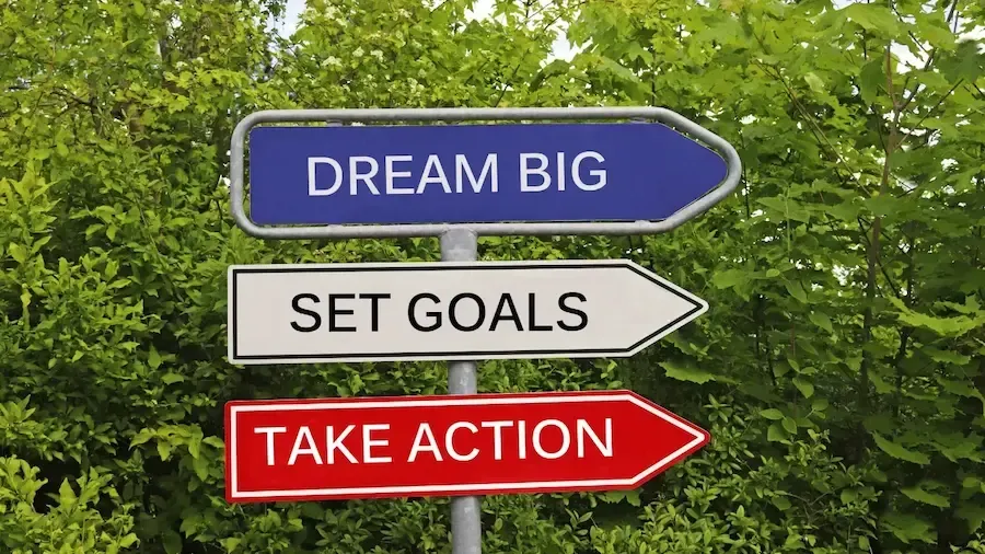 A sign that says dream big set goals take action