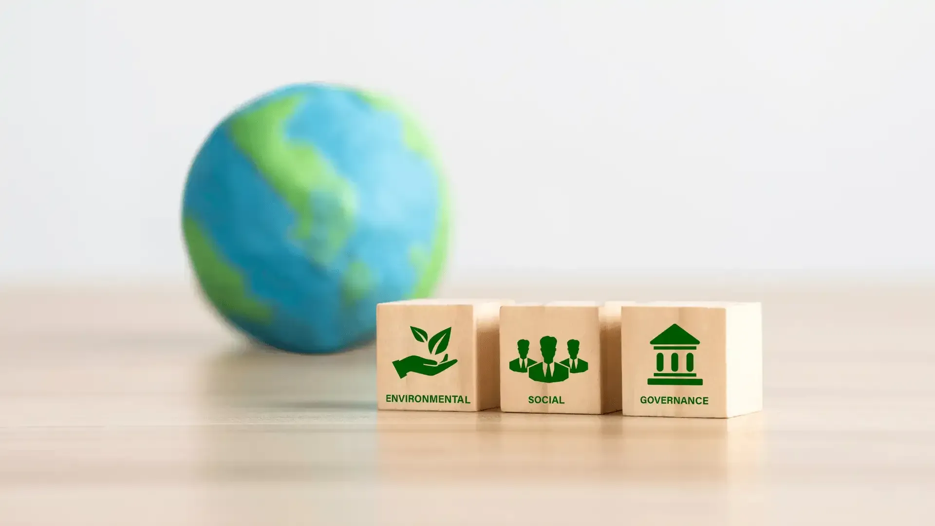 A globe is sitting on a wooden table next to a row of wooden blocks.