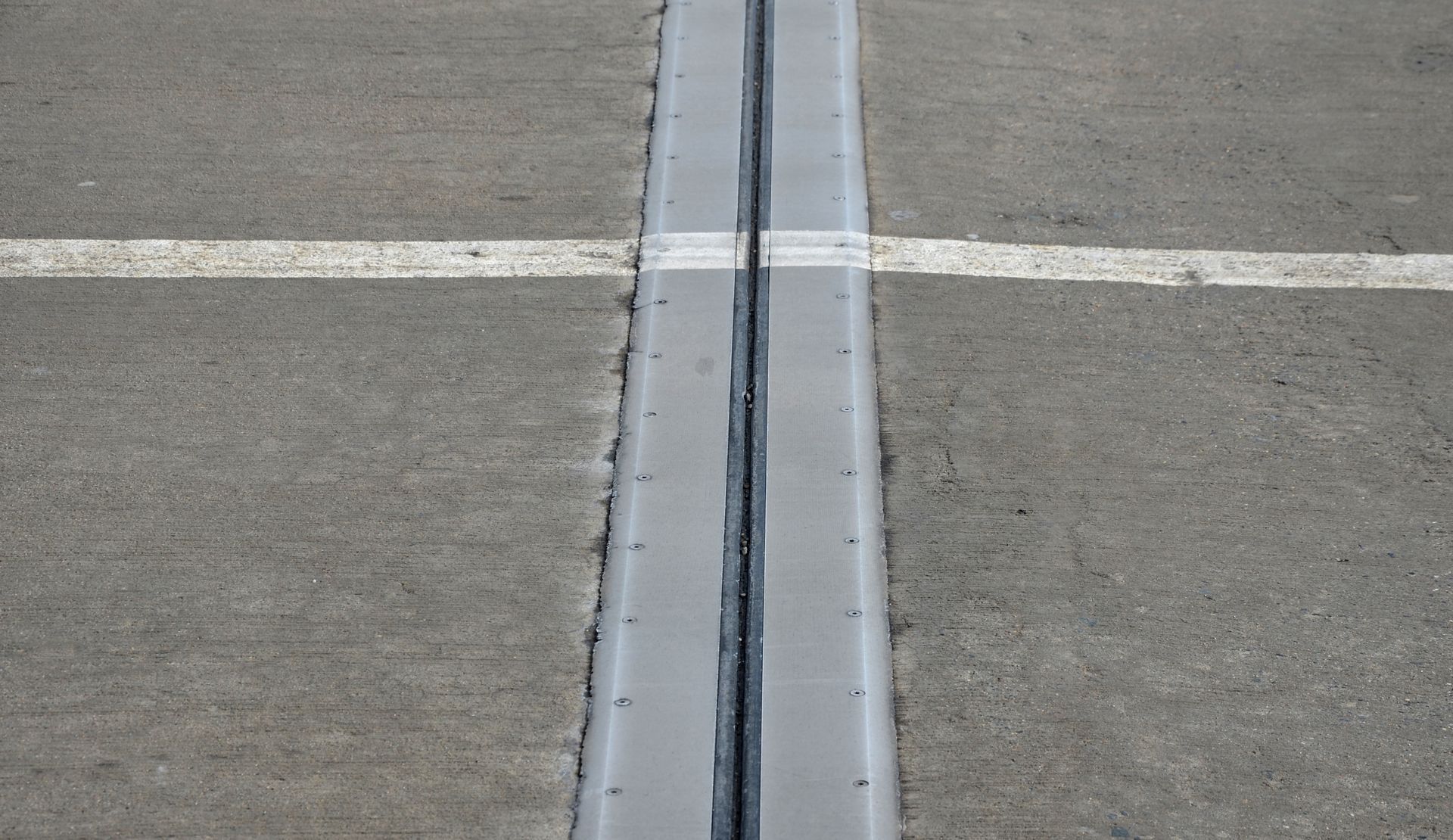 A close up of a concrete drain on the side of a road.