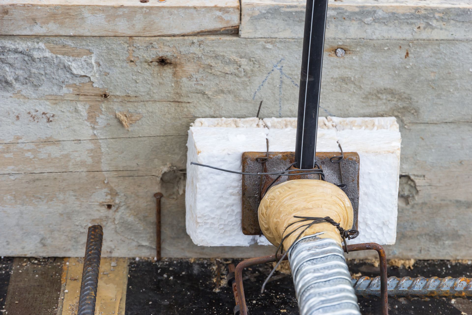 A close up of a hose attached to a wooden wall.