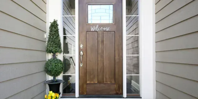 Stone entryway with black double doors and tall sidelights on either side
