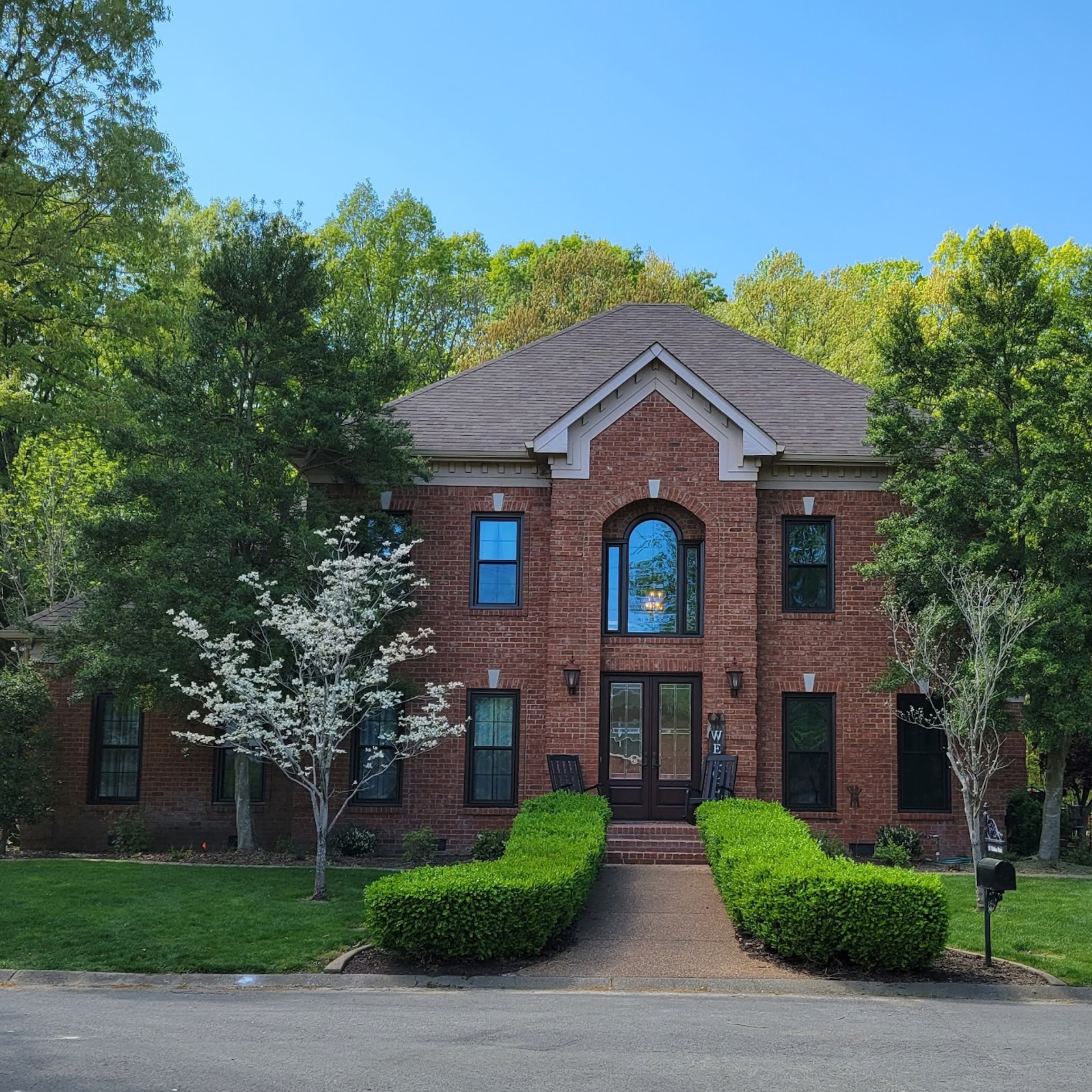 Newly installed black replacement windows on a brick home