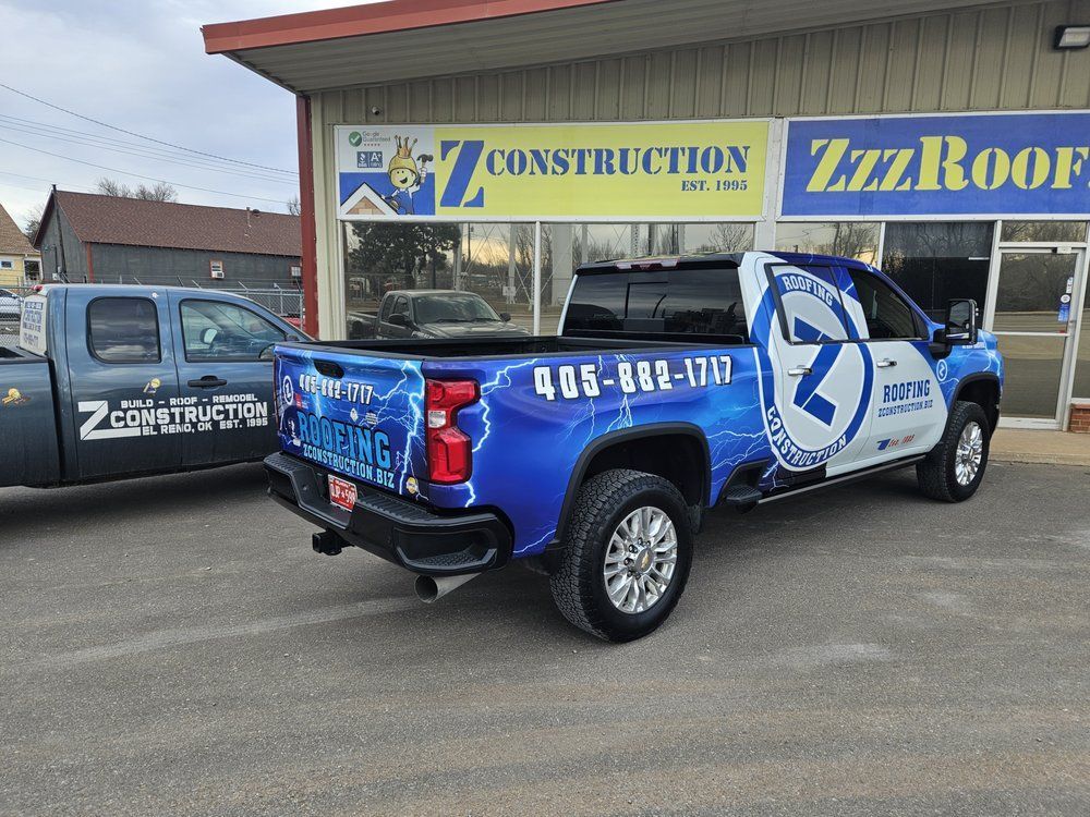 Z Construction and Roofing  trucks parked outside a building with 