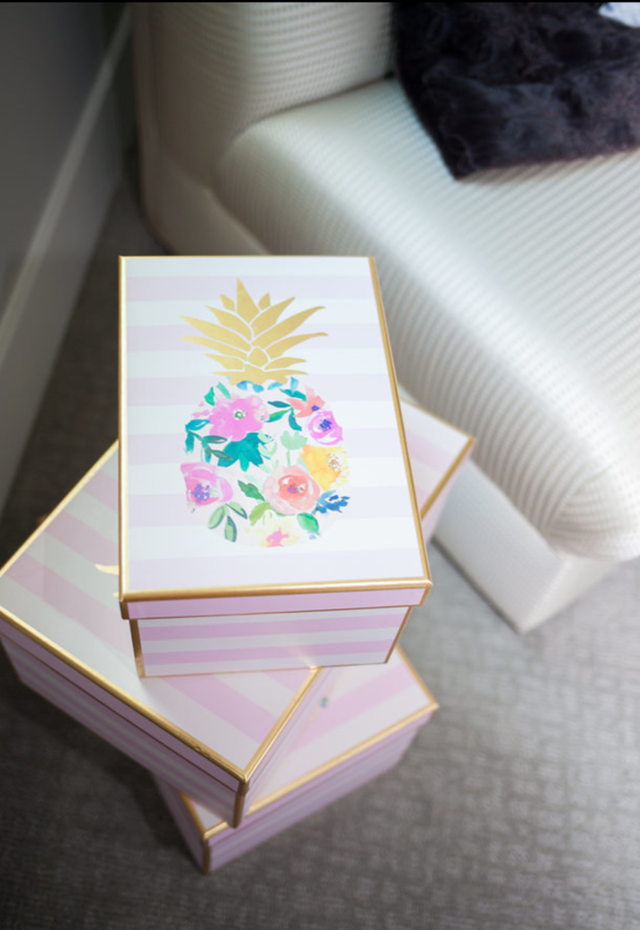 A stack of pink and white boxes with pineapples on them