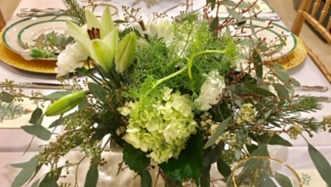 A table with plates and a vase of flowers on it.