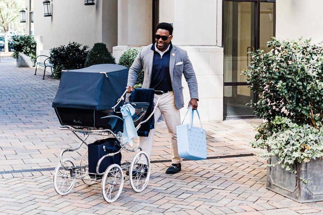A man is pushing a stroller down a sidewalk.