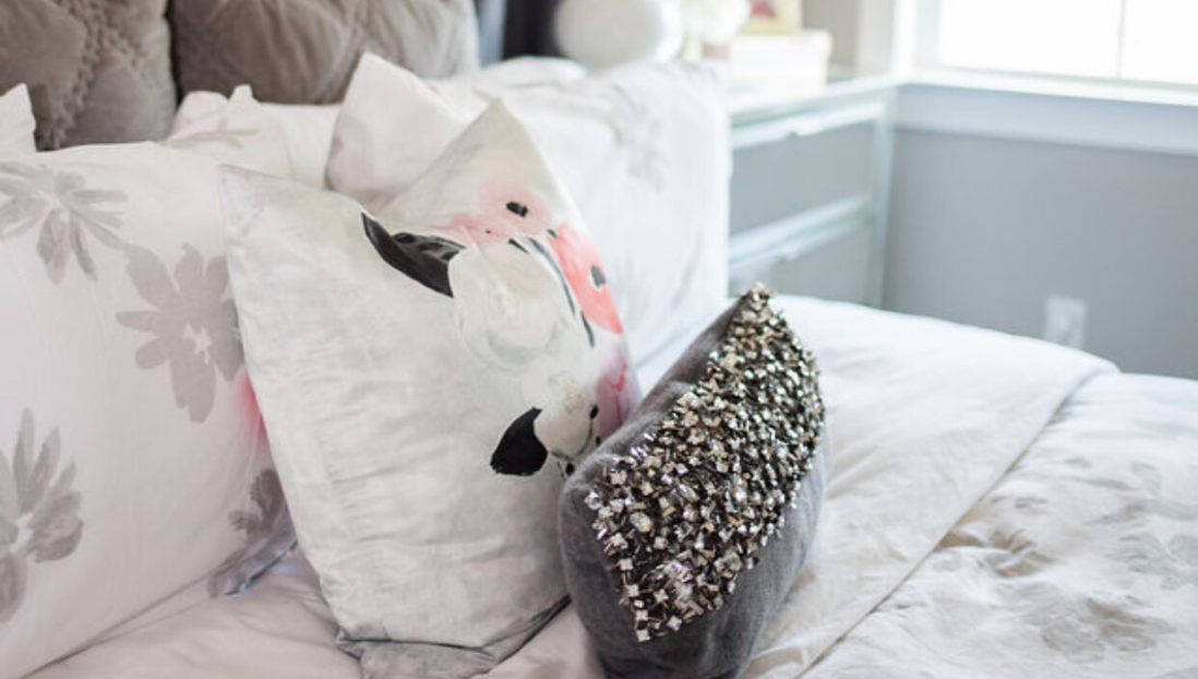 A bed with pillows and a purse on it.