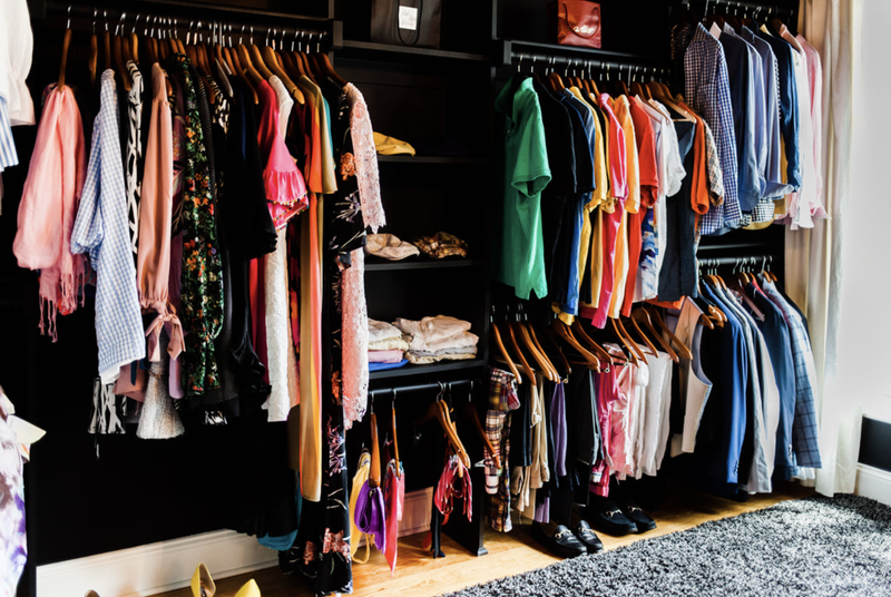 A closet filled with lots of clothes and shoes.