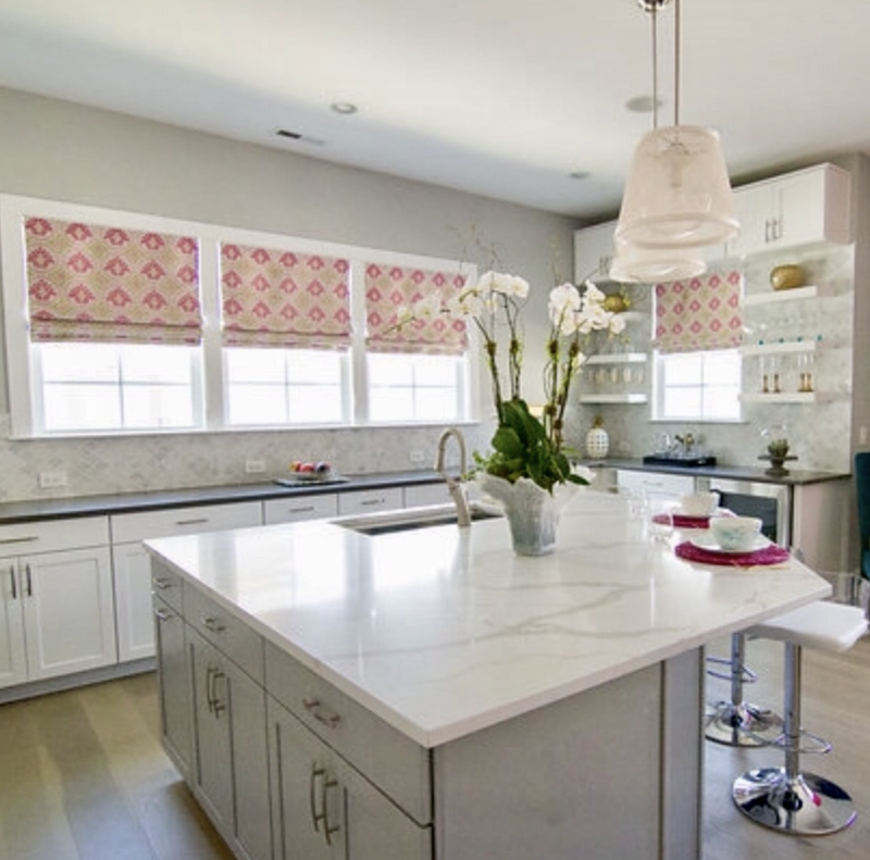 A kitchen with white cabinets and a large island