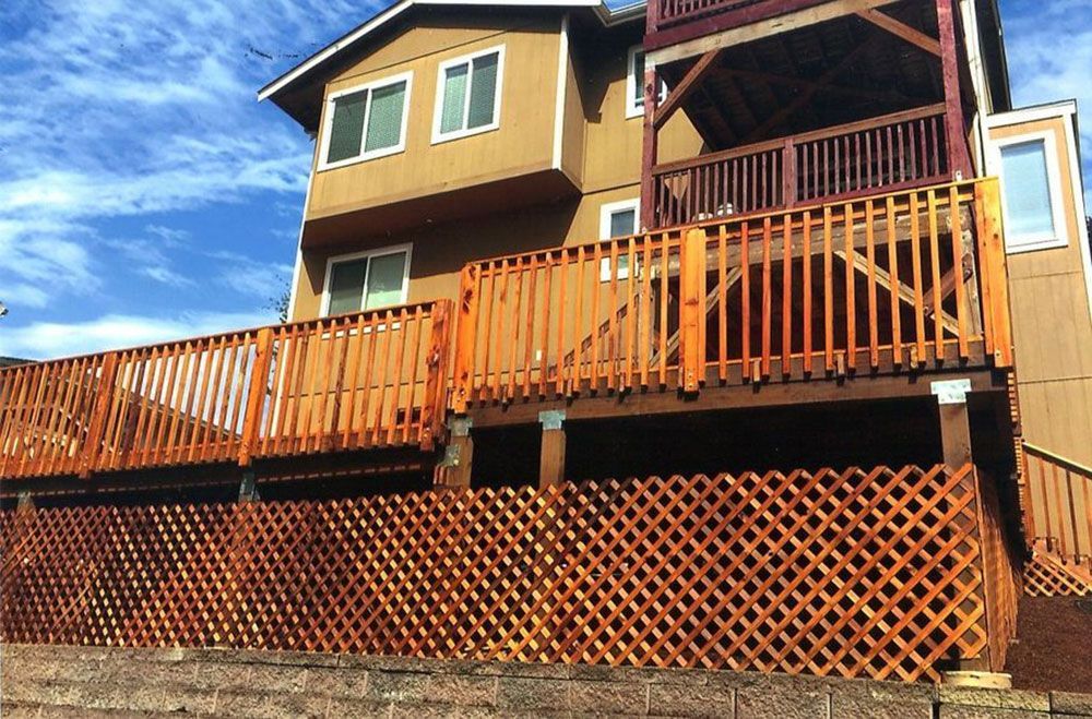 A large house with a wooden deck and fence