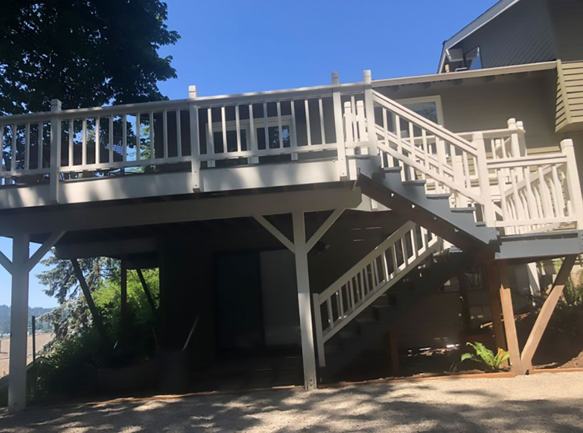 A house with a large deck and stairs leading up to it.