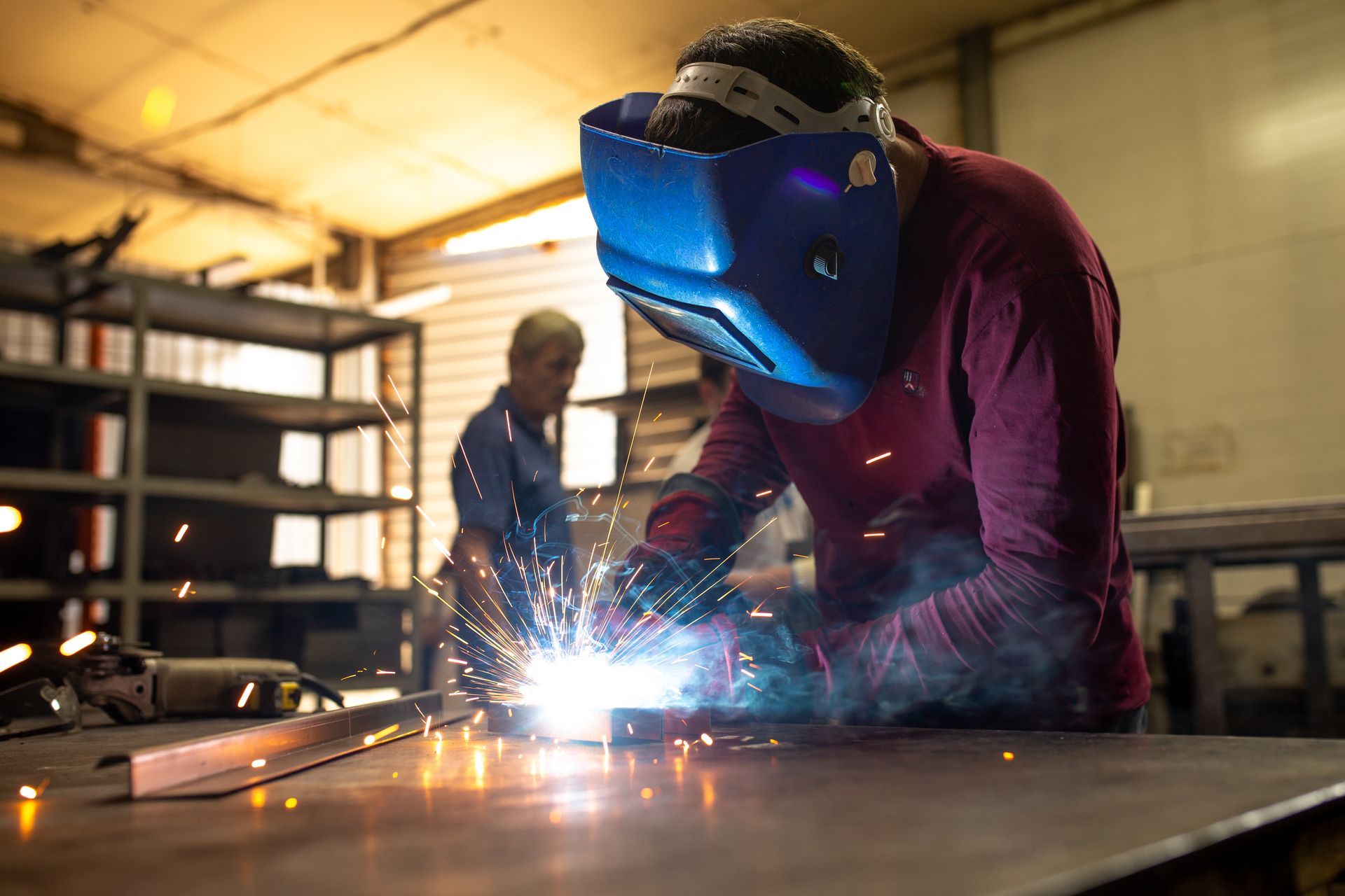 Welder works on a metal surface.