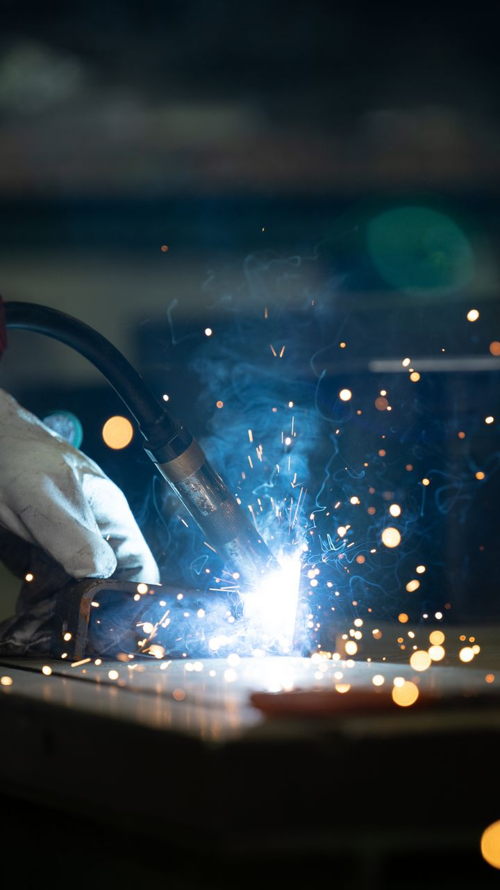 Close-up of welding sparks during residential ironworks fabrication.
