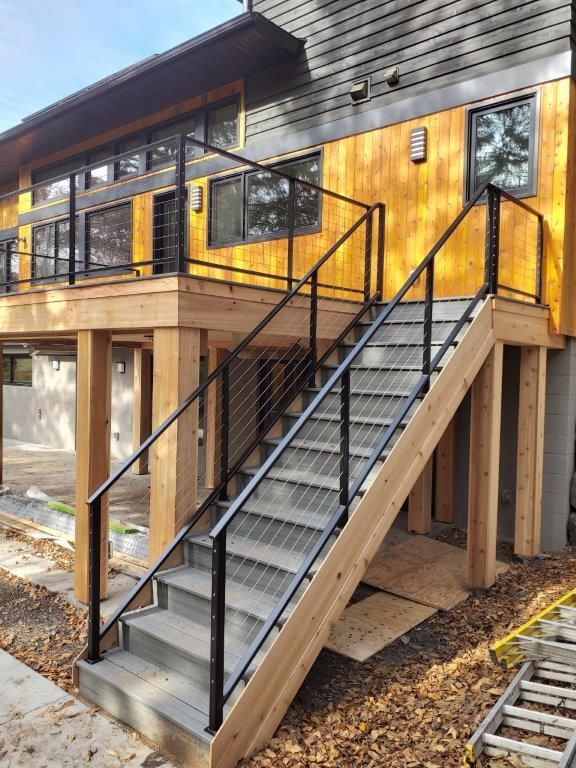 A house with a deck and stairs leading up to it.