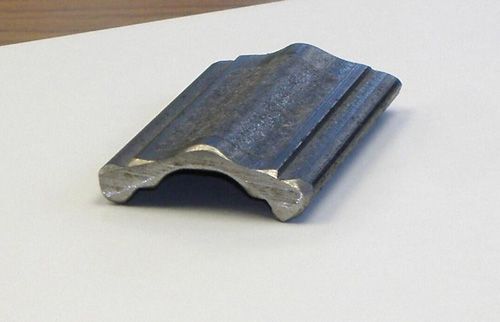 A piece of metal is sitting on a white surface.