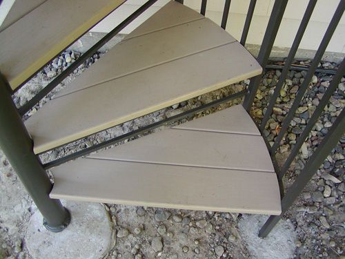 A spiral staircase with wooden steps and a metal railing
