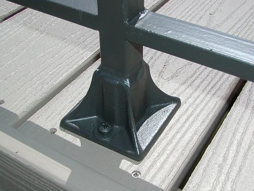 A close up of a metal railing on a wooden deck.
