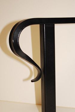 A close up of a black railing with the letter s on it