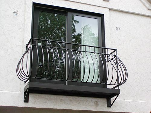 A balcony with a wrought iron railing on the side of a building