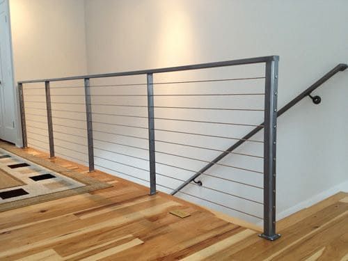 A staircase with a wire railing and a handrail