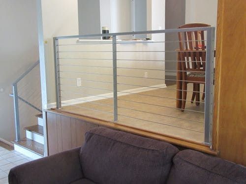 A living room with a couch and stairs leading to a dining room