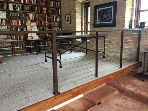 There is a table in the middle of the room with a railing.