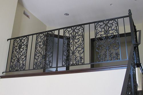 A balcony with a wrought iron railing and stairs
