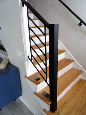 A staircase with wooden steps and a black railing