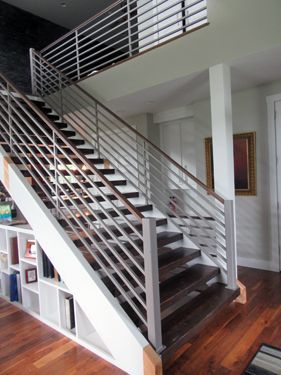 A wooden staircase with a metal railing in a house
