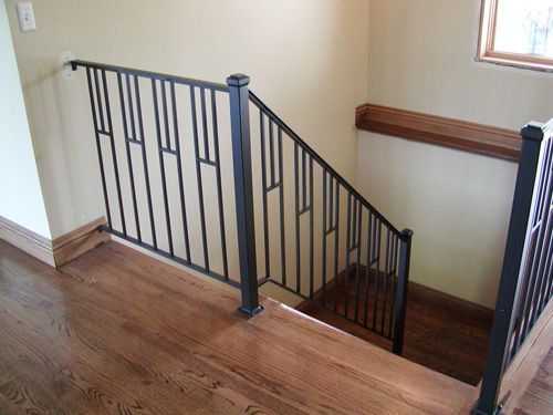 A staircase with a metal railing and wooden steps in a house.
