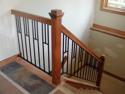 A wooden staircase with a metal railing and a window
