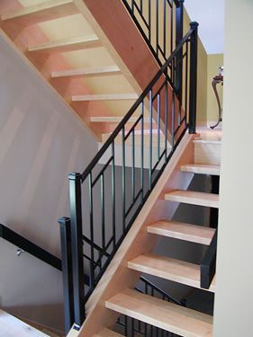 A wooden staircase with a black railing in a house