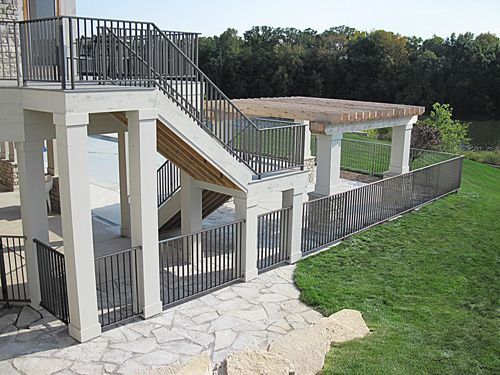 A large deck with stairs leading up to it and a fence surrounding it.