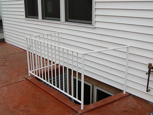 A white house with a white railing on the side of it