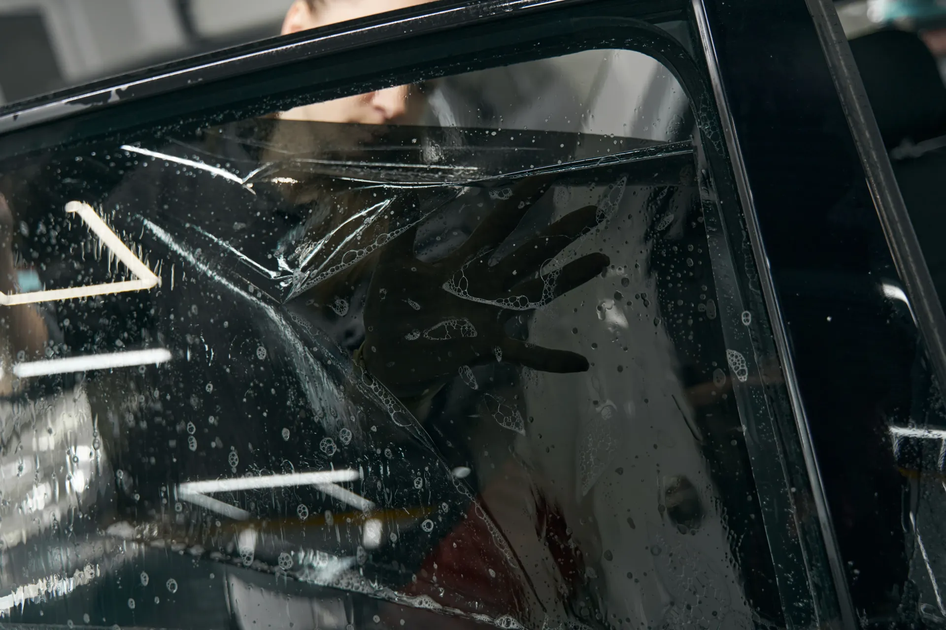 Cracked car side mirror with shattered glass and water droplets
