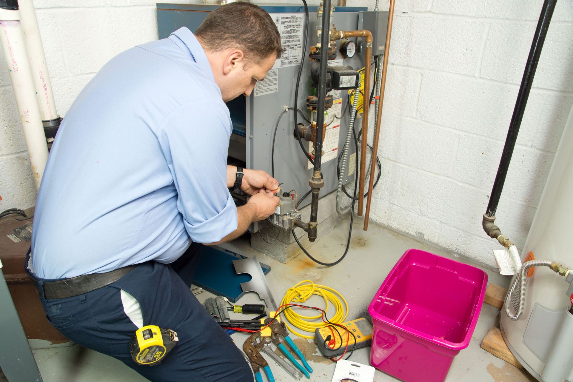 Plumber fixing gas furnace