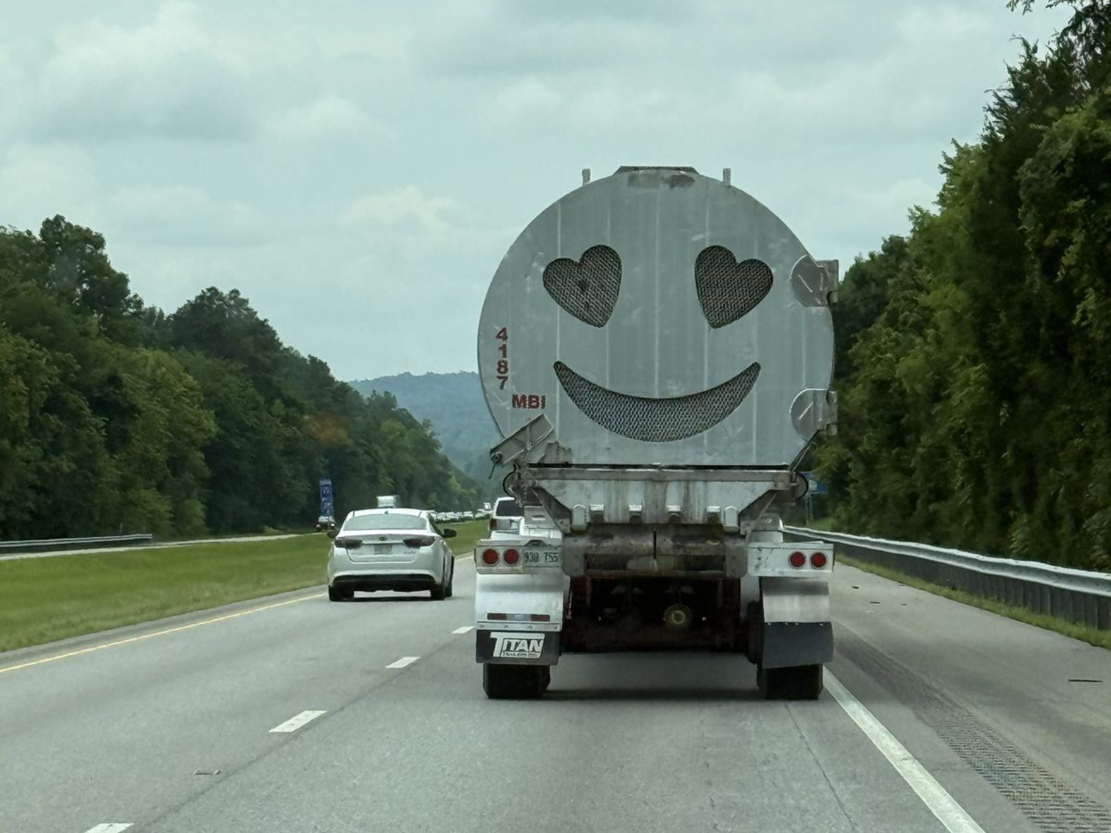 Tanker truck on the interstate with a heart-eyes smiley face cut into the back panel