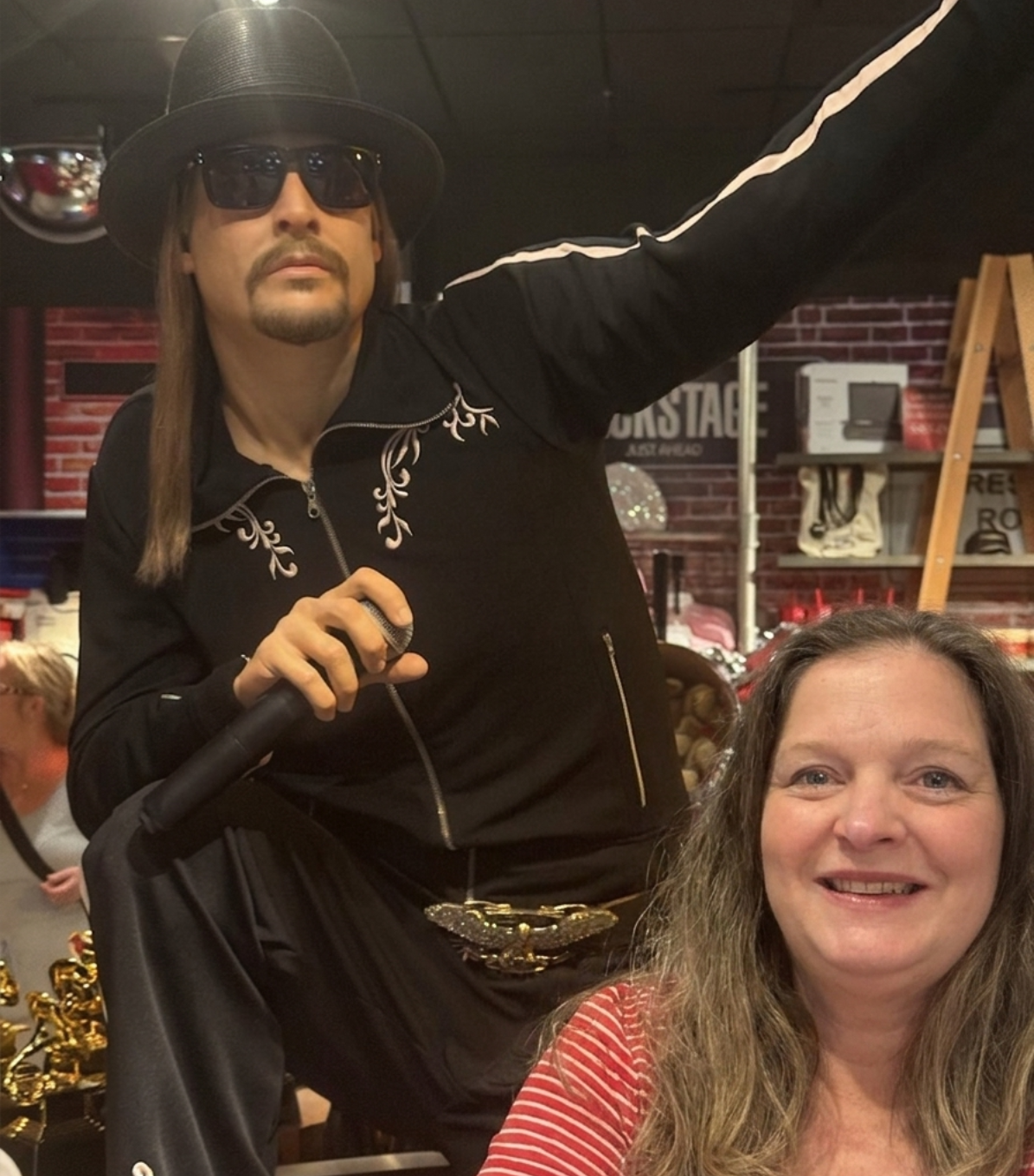 Visitor posing for a selfie with the Kid Rock wax figure at Madame Tussauds Nashville