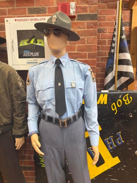 A Georgia State Trooper uniform on display with campaign hat, blue shirt, tie, and belt, showing how consistent signals make an identity instantly recognizable
