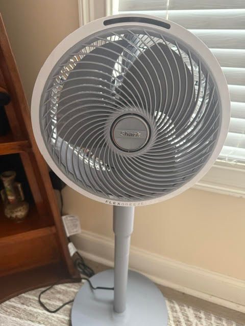 Pedestal fan with a swirled grille pattern, representing AI synthesizing multiple search results into one answer